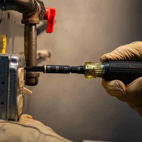 Impact Rated 11-in-1 Multi Bit Screwdriver And Nut Driver used on metal pipe, showcasing interchangeable components in action.