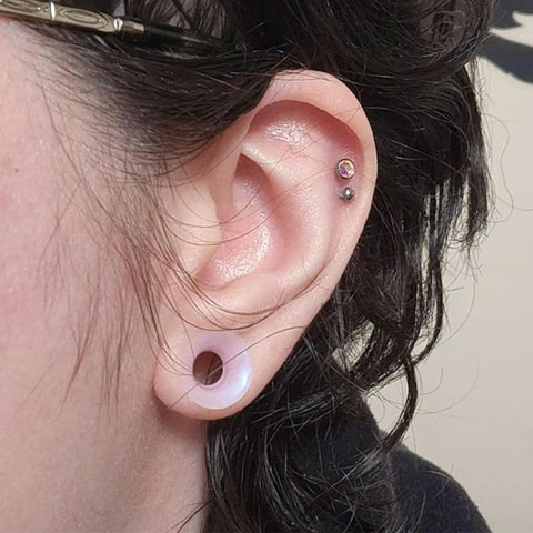 Person wearing 10G Clear Silicone Ear Gauges Tunnels Plugs Retainer Set Four Pairs Ultra Thin Soft Flexible Double Flared Saddle Piercing Jewelry