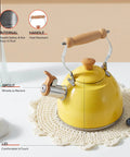 Yellow 1.6 Quart Tea Kettle With Cool Touch Wooden Handle Food Grade Stainless Steel Stovetop Teapot Whistling Kettle For Easy Pour Ergonomic Grip Safe Heat Resistant Kitchen Accessory shown on a table with drinks.