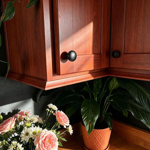 Wooden cabinet with 4 Pack Knurled Round Cabinet Knobs And Drawer Pulls Single Hole Hardware For Kitchen and Bath in Matte Black Finish
