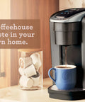 Kick Up Your Morning Routine With This Dope Single Serve Coffee Maker Featuring K Cup Compatibility Strong Brew And Iced Settings Programmable Temp Control Plus Multiple Cup Sizes In Solid Brushed Slate, brewing coffee into a blue cup.