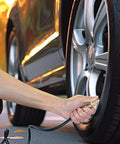 Hand using Garage Ready Dual Head Air Chuck Set With Closed Flow One Quarter Inch NPT Heavy Duty Tire Inflation Kit on car tire