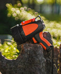 Rechargeable Waterproof Spotlight Up To 4500 Lumens Handheld Beast Mode Searchlight resting on tree stump in sunlight