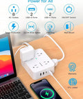 Plug Away With This Slick Flat Surge Protector Power Strip Featuring Eight Roomy Ac Outlets And Four Fast Usb Ports on desk near laptop and smartphone.