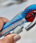 Close-up of hand holding grappling hook with blue rope, part of Survival Grappling Hook With 32ft Rope Four Claw Foldable Stainless Steel Compact.
