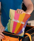 Person holding Rainbow Color Waterproof Poly Mailer Bags 100 Count Self Sealing Shipping Envelopes For Clothes above an orange bag.