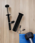 Portable Black Carbon Steel Weight Loading Pin For Gym Equipment on wooden floor with dumbbell and towel