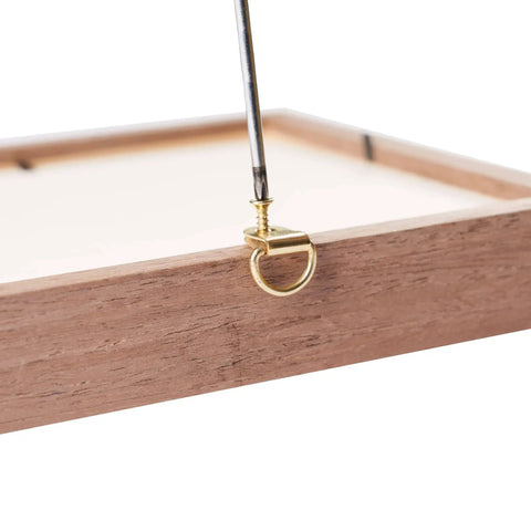 Wooden frame with a brass D-ring, part of the DIY Picture Hanging Hardware Kit 220 Piece Brass Finish Set, holding steel wire.