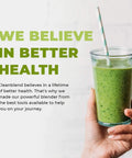 Hand holding a glass of green smoothie with striped straw next to text about better health and powerful blender use.