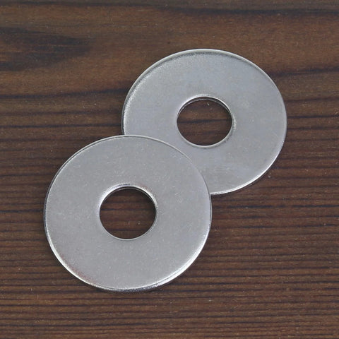Two stainless steel flat washers on a wood surface; 1-inch outer diameter, 0.055-inch thick.