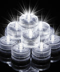 Stack of mini submersible LED lights with remote RGB multicolor waterproof tealight candles glowing on dark background.
