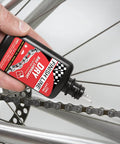 Applying Dry Bike Chain Lube Aerosol With Ceramic Dry Wax for dirt resistant performance on a bicycle chain in dry conditions