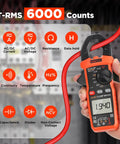 Hand holding Digital Clamp Meter Multimeter 6000 Counts with Auto Ranging True RMS, displaying voltage measurement.