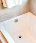 Rock Solid Twist Close Bathtub Drain Trim With One Hole Overflow Faceplate And Universal Connector In Quality Oil Rubbed Bronze Finish Built Tough Fifty Pack installed in a white tub.