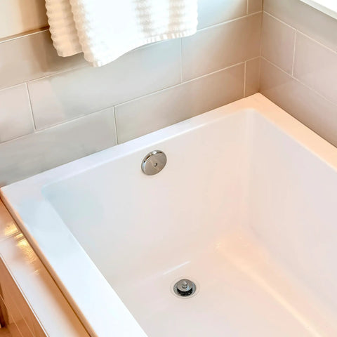Rock Solid Twist Close Bathtub Drain Trim With One Hole Overflow Faceplate And Universal Connector In Quality Oil Rubbed Bronze Finish Built Tough Fifty Pack installed in a white tub.