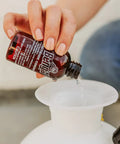 Pouring Indoor Outdoor Bug Killer Concentrate Makes 2 Gallons From 2 Oz Liquid into a sprayer for pest control