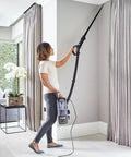 Person using Five Pack 1.25 Inch Vacuum Extension Wands With 1.38 Inch To 1.25 Inch Hose Adapter to clean ceiling corners.