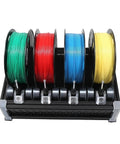 High-quality 3D printing filament spools in green, red, blue, and yellow on a sturdy black holder, showcasing vibrant colors.