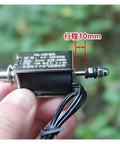 Close-up of 24V Linear Push Pull Solenoid Electromagnet Open Frame With Spring Plunger 10mm Stroke, hand-held with wiring visible.