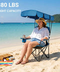 Person on Heavy Duty Oversized Portable Canopy Camping Chair With Sunshade 380 Lb Capacity Folding Lawn Chair at beach