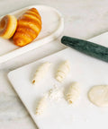 French Marble Rolling Pin With Wooden Resting Base 15 Inch Nonstick Dough Roller with pastries and dough on a countertop.