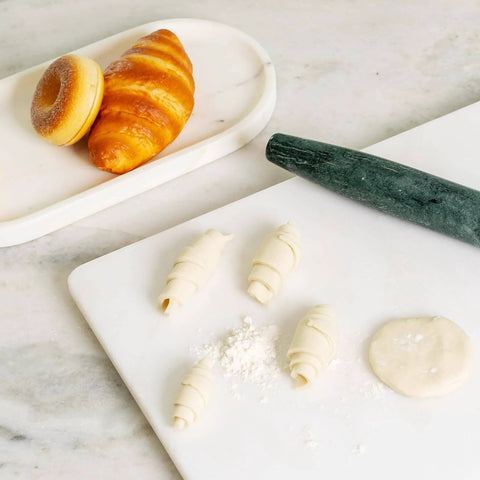 French Marble Rolling Pin With Wooden Resting Base 15 Inch Nonstick Dough Roller with pastries and dough on a countertop.