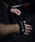Sick Grip Black Cotton Lifting Wrist Straps Featuring Hella Padded Neoprene Cuffs for Heavy Deadlifts and Powerlifting Beast Mode Workouts Demanding Serious Wrist Support and Flawless Form During Tough Training Days, being secured on wrists.