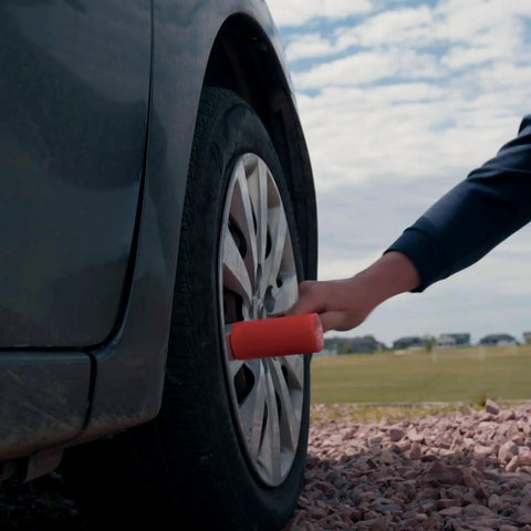 Hand using Dead Blow Hammer 4 Lb Mallet With Non Marring Rubber Coating For Wood And Metal Heavy Duty Build Orange Grip on car tire