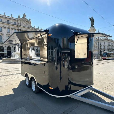 Slick 12 Foot Black Stainless Steel Commercial Food Trailer Equipped With Turnkey Mobile Beer Bar Station And Tough Catering Gear For A No Fuss Pop Up Hustle, angled view in plaza.