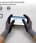 Hands wearing MicroFoam Nitrile Coated Work Gloves using a smartphone, showing seamless knit nylon, gray, size 10/XL.