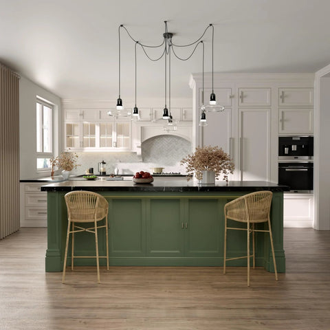 Modern kitchen with green island, wicker bar stools, hanging pendant lights, and white cabinets; neutral decor style.