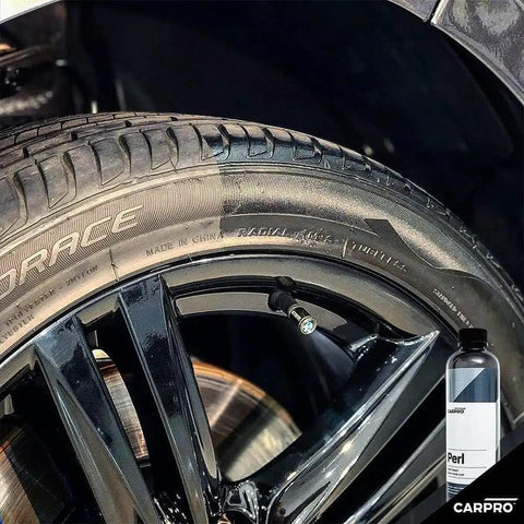 Perl Coat Plastic And Rubber Protectant for Cars revives tire and rim with UV shield, visible next to 500 mL bottle.