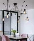 Five Head Adjustable Industrial Pendant Light With Vintage Spider Design, hanging in modern dining room over table.