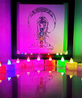 Color Changing LED Tea Lights 24 Pcs Flameless Tealight Candles with colorful lights in front of abstract art, white base, 7 color cycle