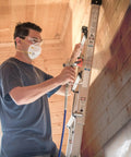 Heavy Duty Cart Airless Paint Sprayer For Interior And Exterior Jobs Featuring Stainless Steel Piston Pump in use on a ladder.