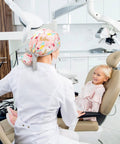 Dentist wearing 8 Pack Women's Scrub Caps With Buttons In Eight Different Patterns Adjustable Bouffant Surgical Hat With Ponytail Holder