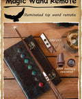 Magic Wand Remote with illuminated tip and AAA battery, resting on a decorative book.
