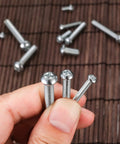 Close-up of carbon steel screws from 720 Piece Nuts And Bolts Kit With Carbon Steel M3 M4 M5 Screws Nuts And Washers In Cross Pan Head Machine Screws Set Heavy Duty Storage Case For DIY Projects And Garage Fixes.