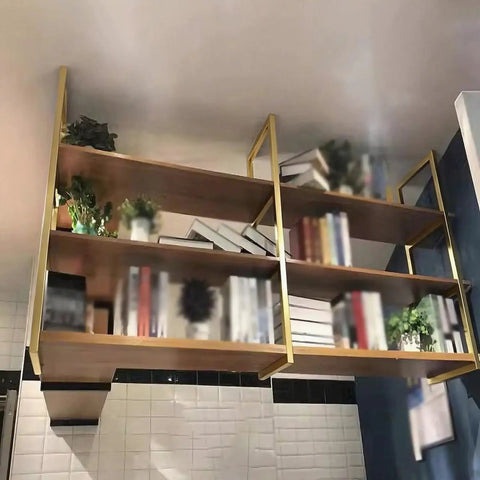 Beast Mode 3 Tier Floating Shelf Brackets Industrial Wall Mount Hardware For Ceiling Install, gold iron brackets supporting wooden shelves with books.