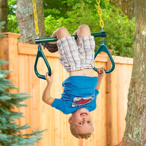 Child hanging upside down on Heavy Duty Gym Rings Trapeze Swing Bar with 16 inch bar and 47 inch chain in backyard setting.