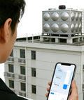 Person monitoring a building rooftop water tank with a phone app using Non Contact Ultrasonic Level Sensor With 2.4G WiFi For Water Tank And Grain Bin, Remote Level Monitor For Liquids And Solids, No Touch Control Via Tuya Smart And Smart Life App, Outdoor Waterproof Tank Indicator Alarm.