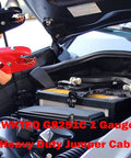 Hands holding Heavy Duty Jumper Cables 1 Gauge 25 Foot 800 Amp connecting to a car battery for jump starting.