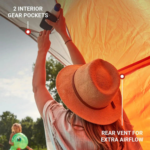 Person inside Lightweight Beach Shade Tent With Pre Attached Poles Large Sun Shelter For Sand And Sun showing rear vent and gear pockets