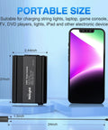 Road Ready 150 Watt Car Power Inverter Plugs Straight Into Cigarette Lighter To Crank Out 12V DC To 110V AC With Dual 3.1A USB Ports And Standard Outlet For Solid Everyday Charging On The Fly in portable size next to smartphone.