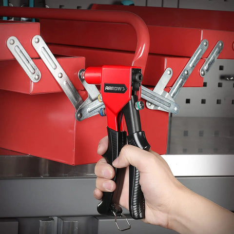 Pro Grade Hand Riveter Kit With Four Interchangeable Heads for metal work, tool held over red metal piece for installation