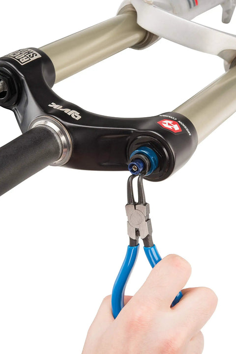 Hand using Pro Grade Snap Ring Pliers Set RPSET-2 With Straight Internal Tip to maintain bike suspension