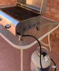 Propane Regulator And Hose 2 Ft With Three Eighths Inch Female Flare Replacement Grill Part Fit For Weber Spirit Genesis Blackstone Griddles Patio Heaters Fire Pits And More connected to a grill on patio.