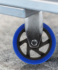 Hassle Free Heavy Duty Directional Plate Casters Featuring 5 Inch Black Rubber Wheels And Silent Non Swivel Design For Dead Simple Rolling On Trolleys Workbenches And Shop Carts, close-up of blue rubber wheel.