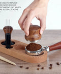 Top Shelf Espresso Tamper And Coffee Distributor Station Kit Featuring Natural Wood Handle Anti Slip Base Pro Level 53Mm Portafilter Tool For Home Kitchens with hand pressing coffee grounds.