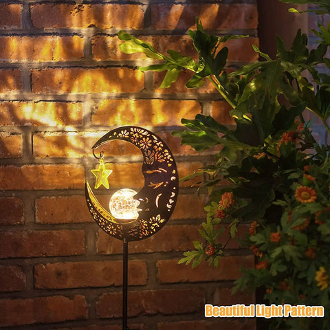 Lit Moonlit Solar Lantern for Outdoor Decor casting warm LED glow against brick wall with crackle glass globe, bronze finish.